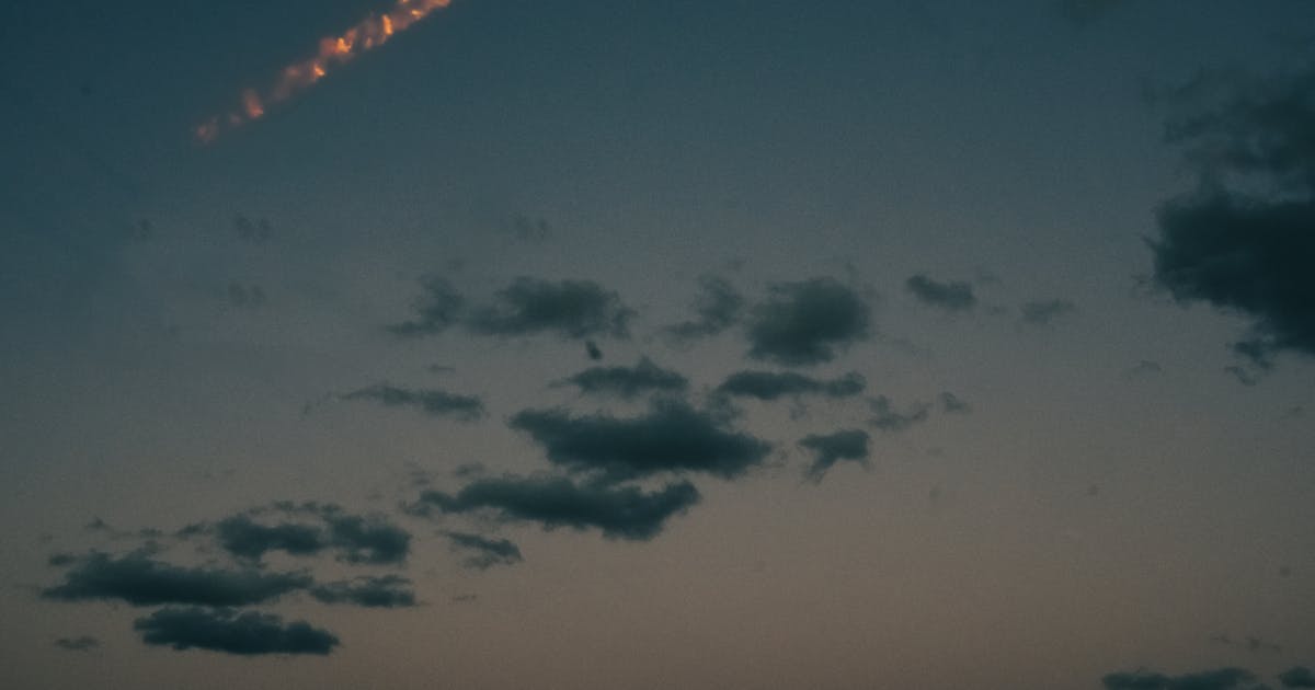 暮色天空中一道明亮的火光軌跡劃過雲層